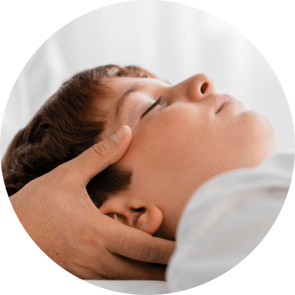 Tête d’un enfant détendu, recevant un massage apaisant.